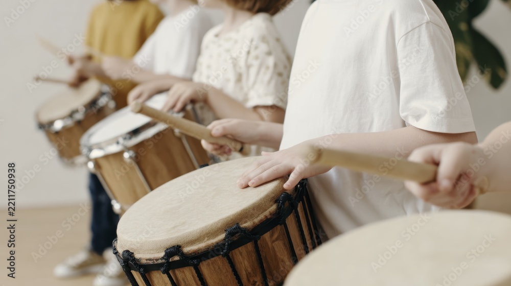 Fototapeta premium Children playing drums in a music class for creative learning and expression