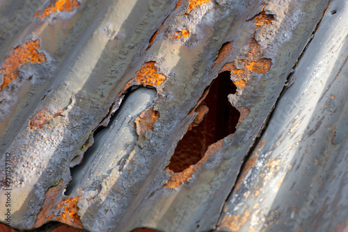 Rusty corrugated metal roof on a red wooden house
