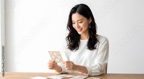 Elegant Japanese woman smiling while reading heartfelt greeting card at home