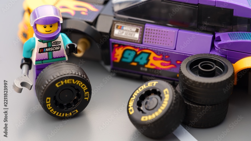 Obraz premium Tambov, Russian Federation - January 17, 2026 A Lego driver minifigure changing wheel on a Lego NASCAR Next Gen Chevrolet Camaro ZL car.