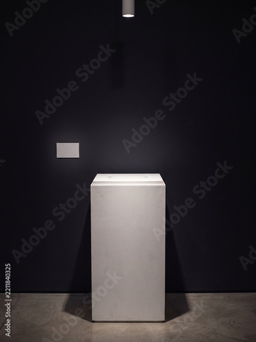 Empty White Museum Pedestal Under Spotlight With Blank Label