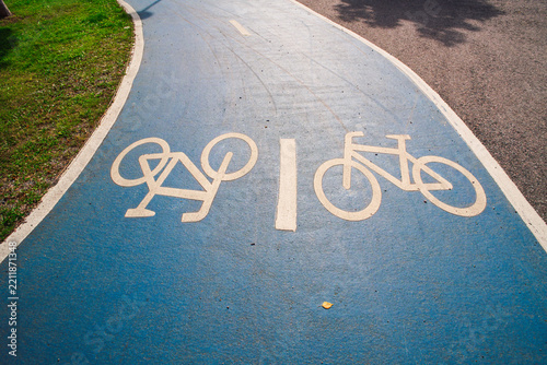 View of a blue painted bicycle lane with white bicycle symbols on the asphalt in Helsinki, Uusimaa, Finland.