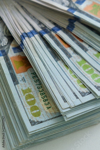 Financial and business concept photography featuring stacks of bundled US one hundred dollar bills, representing wealth, banking, finance, investment, economy, and cash flow.