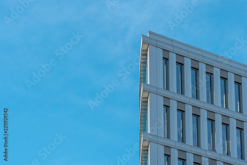 Modern corporate office building facade corner against a clear blue sky with ample copy space   