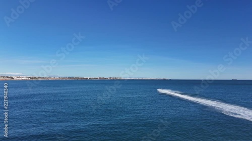 Jet Ski Riding Across Blue Sea Near Coastal City