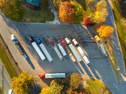Big parking car and truck stop for tractor trailers and personal vehicles. Rest area near busy American highway. Hauling cargo concept.
