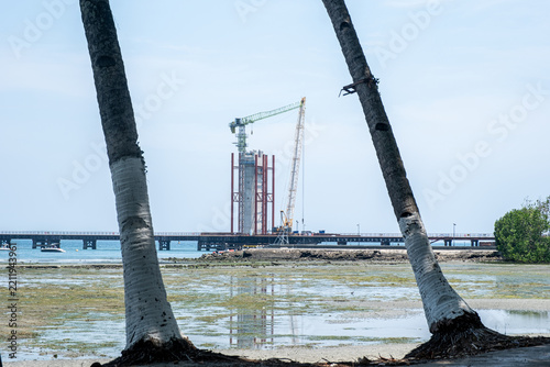 Davao-Samal Bridge construction progresses with workers and machinery along the coast