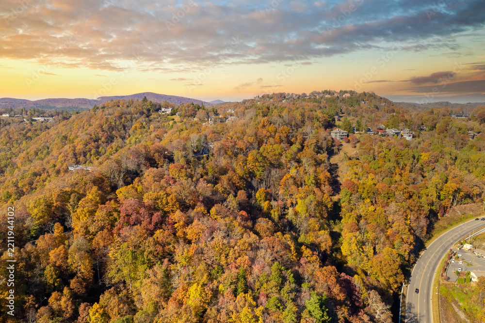 Obraz premium Rural houses between golden woodlands of North Carolina in fall season. Appalachian mountains with dense forest canopies.