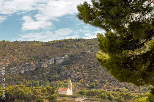 Stone Church Surrounded by Pine Forest and Rocky Hills