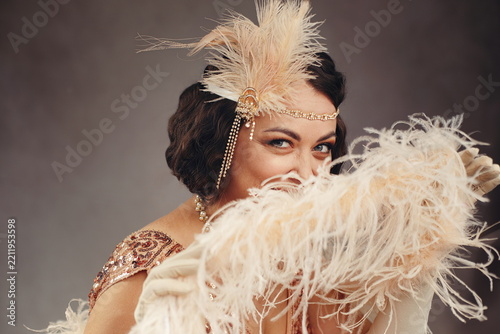 Playful 1920s Flapper Woman Peeking Behind Feather Boa - Great Gatsby Style