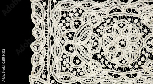 Ribbon lace tape isolated on black background, bobbin lace with gimp trim, vintage textile design, antique fabric art, doily. Border art vintage design