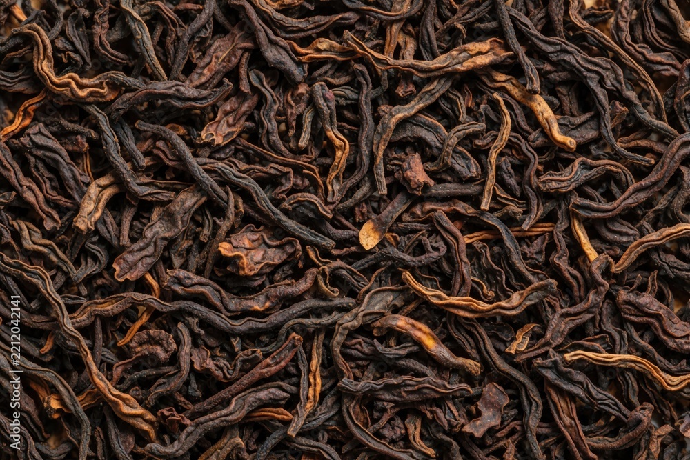 Fototapeta premium Macro texture of dry loose black tea leaves. Organic dark tea ingredients pile for beverage agriculture concept. Close up view shows natural herbal leaf pattern with rich detail. Dried tea background