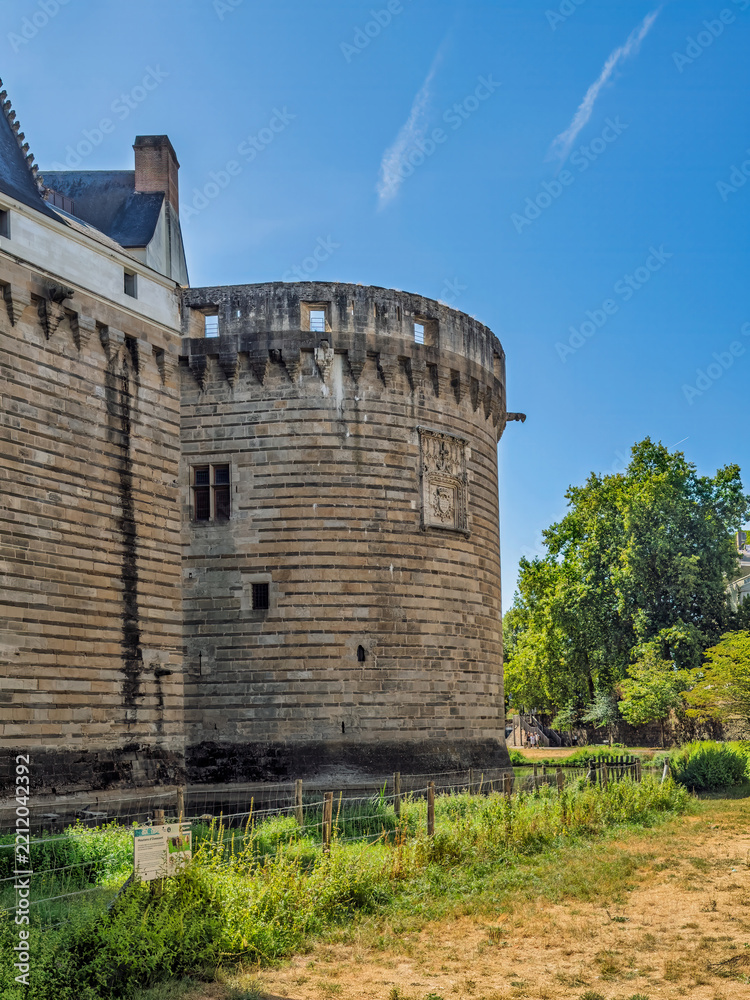 Obraz premium Nantes, France, Europe - August 7, 2026: Château des ducs de Bretagne, Castle of the Dukes of Brittany. Bastion or circular defensive tower along the ramparts with Battlement and parapet on topMoat un