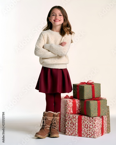 Smiling young girl in festive winter clothing with Christmas presents