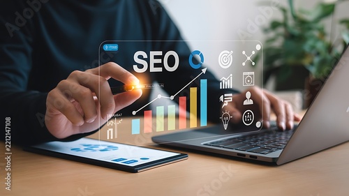Person touching a futuristic SEO dashboard with digital growth charts and icons during a business meeting