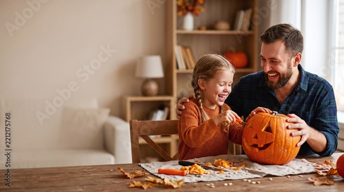 Happy Family Carving Pumpkins Together at Home on Wooden Table in Natural Lighting with Copy Space