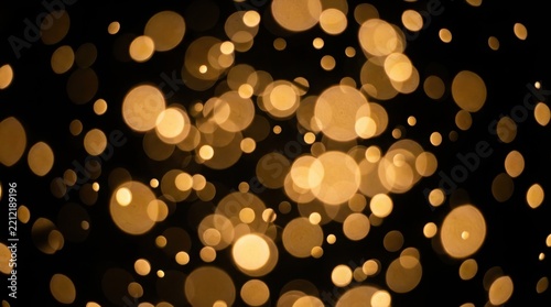 Abstract golden bokeh lights glowing on dark background with light bokeh blurred lights gold particles background texture glittering background light effect magic dust shining bokeh magic glow