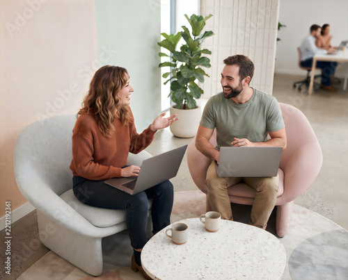 Two colleagues discussing at modern office workspace