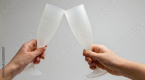 Two hands clinking empty wine glasses