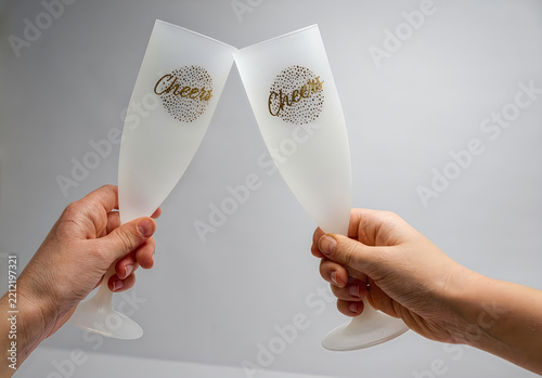 Couple clinking champagne flutes with cheer labels