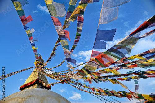 Colorful Tibetan Prayer Flags Fluttering Against Blue Sky at Boudhanath Stupa in Kathmandu, Nepal