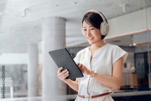 Person using tablet and smartphone with headphones in kitchen