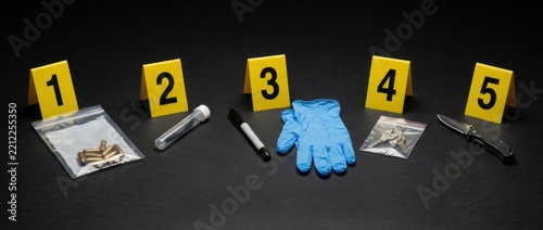 Crime scene evidence markers 1 5 with bullets test tube marker glove drugs and knife on black background