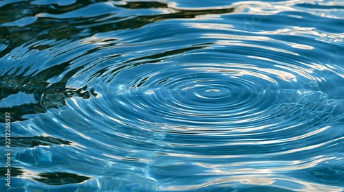 Rippling blue water creates concentric circles reflecting light, representing movement and tranquility in a serene setting