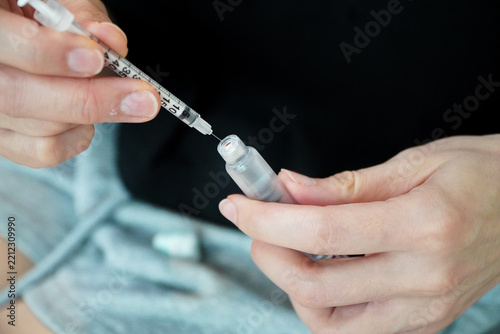 man is filling a clear liquid into a syringe for weight loss.concept of weight loss using pen techniques.
