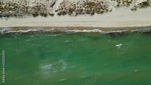 Drone footage capturing the wild and scenic sandy coastline of Flamingo beach with turquoise sea water near Tigkaki village on Kos island, Greece.