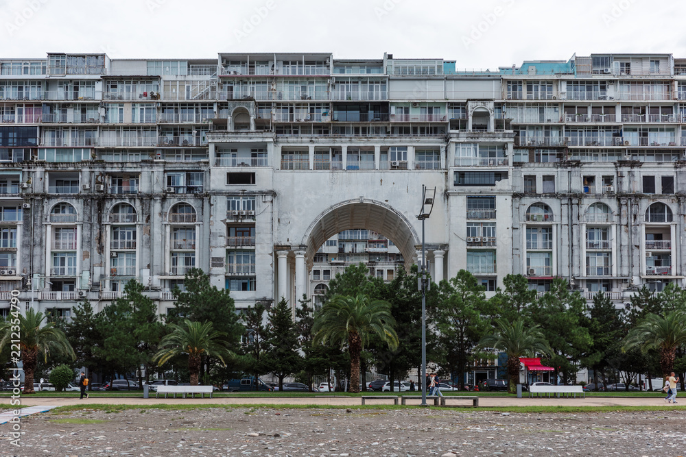Fototapeta premium Residential complex architecture with weathered facade, concrete balconies and deterioration represents maintenance issues, aging housing, dense urban development and property rehabilitation.