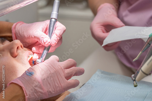 Female dentist and assistant are working with patient in dentistry clinic