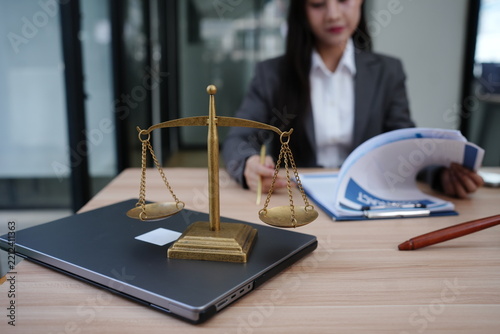Female Lawyer Reviewing Contract Documents with Scales of Justice