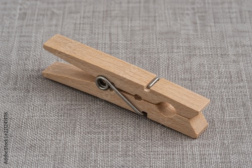 Single unmarked wooden clothes peg on gray linen