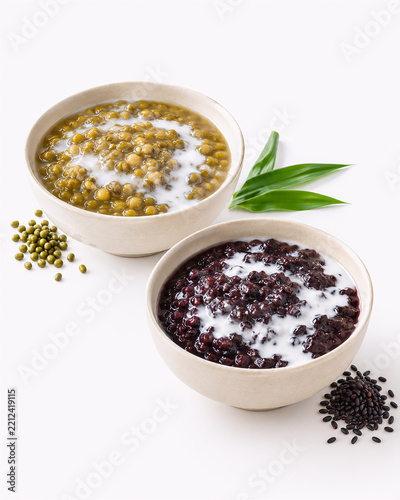 Indonesian sweet porridges, Bubur Kacang Hijau (mung bean) and Bubur Ketan Hitam (black glutinous rice), topped with coconut milk, served with grains and pandan leaves.
