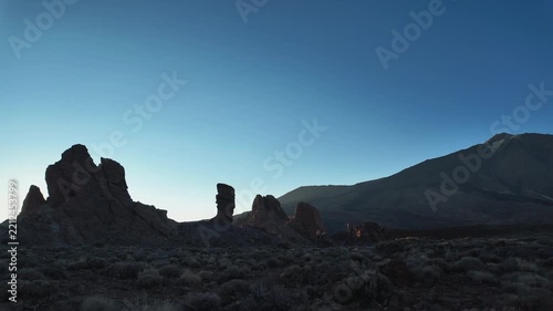Silhouettes of the volcanic rock formations of Roques de Garcia against a deep blue dawn sky in Teide National Park, Tenerife, Canary Islands.