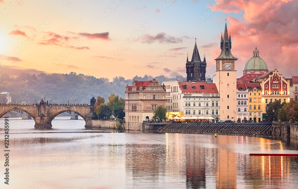 Fototapeta premium Fall landscape view to Charles bridge on Vltava river in Prague Czech republic with blue sky and sunset.