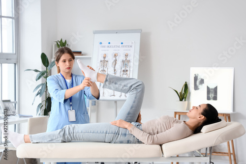 Physical therapy and rehabilitation, physiotherapist examining patient leg in...