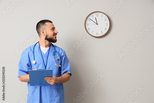 Fotografie Healthcare time management and medical shift pressure, doctor looking at wall cl