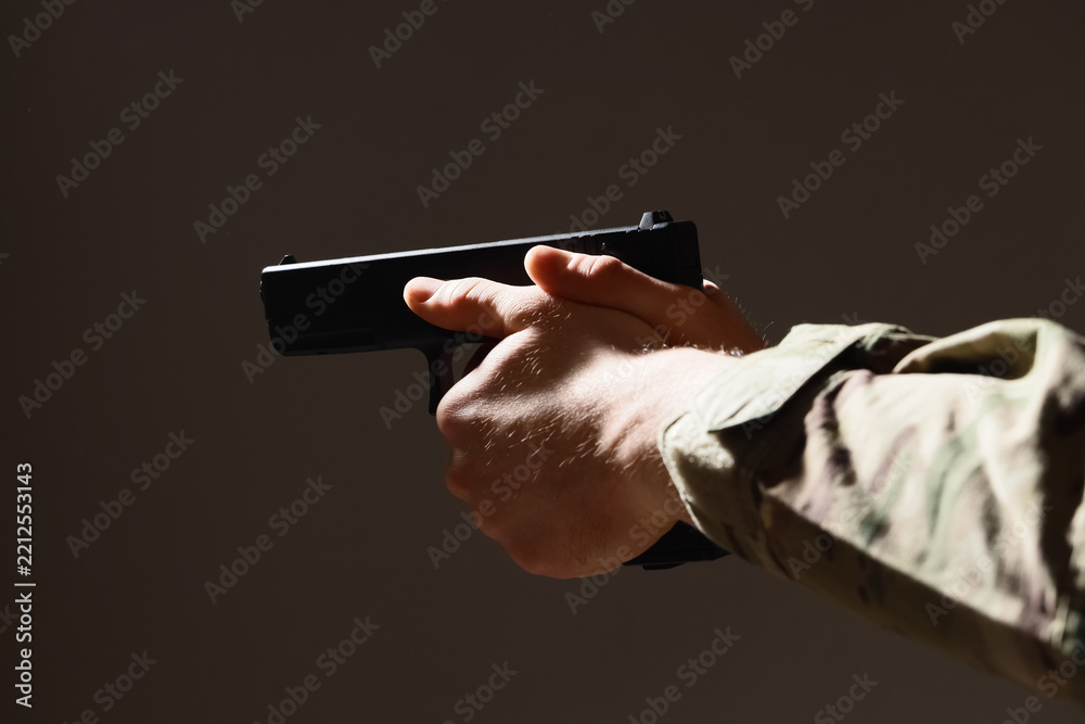 Obraz premium Armed conflict and military security, soldier holding a handgun in a tactical stance for combat training and defense operations in a dark environment