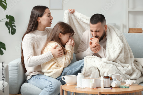 Ill family covering with plaid on sofa at home