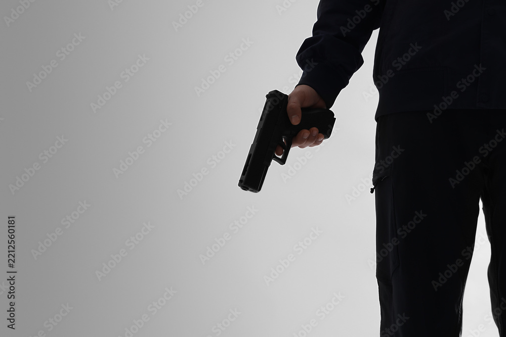 Obraz premium Crime and violence prevention, person holding a handgun in a dark silhouette for security threat, law enforcement or criminal activity