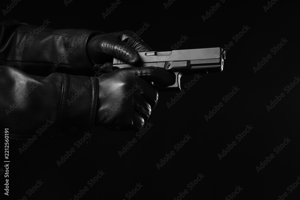 Obraz premium Crime and criminal activity, person in leather gloves holding a handgun in a dark environment for security threat and law enforcement investigation