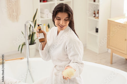 Self care and skincare routine, woman in bathrobe holding lotion and sponge f...