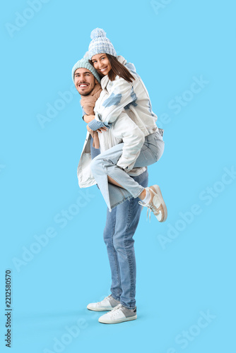 Loving couple in winter clothes on blue background