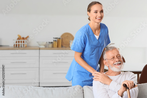 Home healthcare and senior care, professional caregiver supporting happy elde...