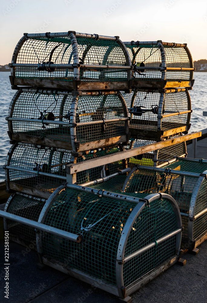 Fototapeta premium Commercial fishing and sustainable seafood industry, stack of lobster traps on a harbor pier at sunset with ocean background and golden hour light