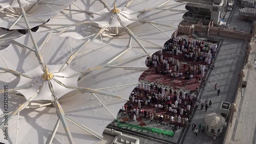 Muslim worshippers performing congregational prayer (Sujud) together in the courtyard of a mosque.