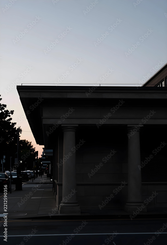Fototapeta premium Urban architecture and city life, neoclassical building facade with columns at dusk in a quiet street with evening sky and silhouettes of parked cars