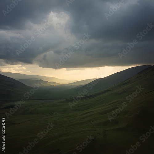 Atmospheric Mountain Valley Illuminated by Dramatic Sunlight Beneath Heavy Storm Clouds and a Moody Sky
